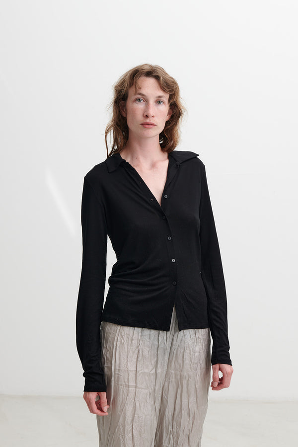 This a timeless classic piece from Blacktogrey. It is a slim-fitted knit shirt made in tencel.